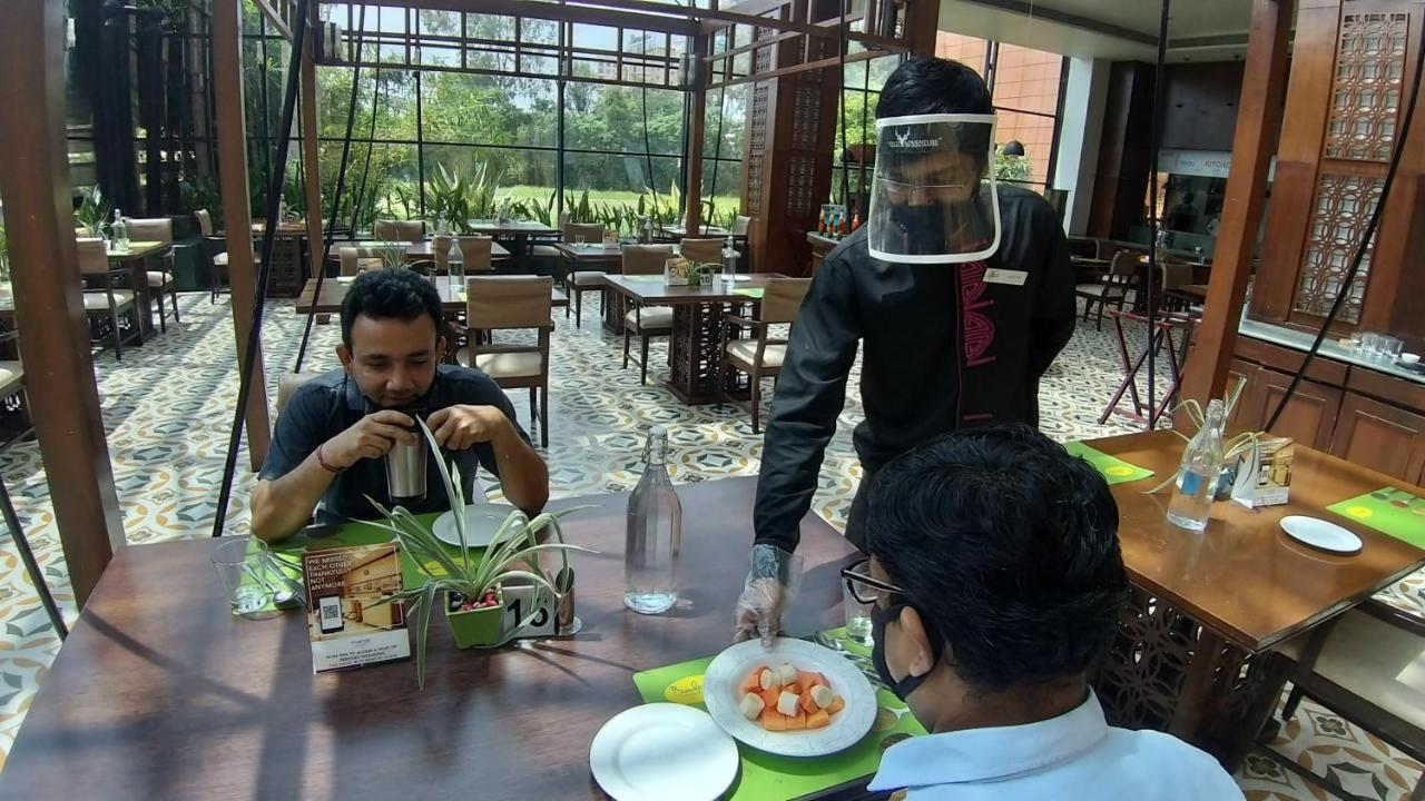 The Orchid Hotel Hinjewadi Púna Exteriér fotografie A restaurant in India with a waiter wearing a face shield